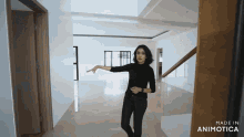 a woman in a black shirt is standing in an empty room with the words made in animatica on the bottom