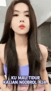 a woman with long hair is wearing a purple top and pink skirt