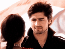 a man with a beard looks at a woman with a braided hair