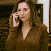 a woman in a brown dress is talking on her cell phone