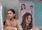 a woman sitting in front of a computer and another woman sitting in front of a picture
