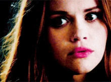 a close up of a woman 's face with long hair and pink lips