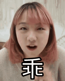 a girl with pink hair has a chinese symbol above her face