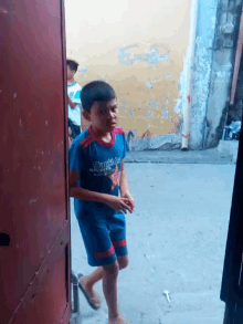 a young boy wearing a shirt that says spiderman