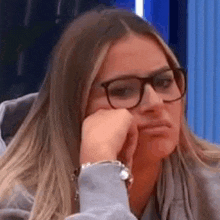 a close up of a woman wearing glasses and a watch .