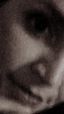 a close up of a person 's face with a blurred background and a black eye .