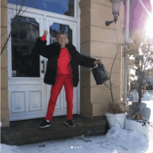 a woman in a red sweatshirt and red pants is standing in front of a door