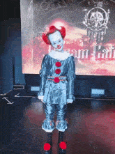 a person dressed in a clown costume is standing in front of a screen that says " team bat " on it