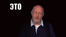 a man with glasses and a beard is speaking in russian .