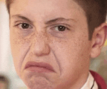 a close up of a young boy making a funny face .