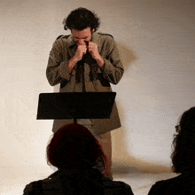 a man playing a harmonica while standing in front of a podium