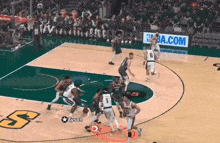a basketball game is being played on a court with nba.com advertisements in the background