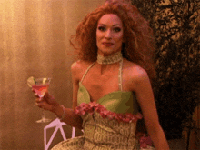 a woman in a dress is holding a martini glass