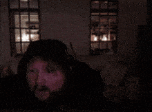 a man with a beard is wearing headphones and a black hood