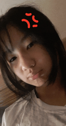 a young girl with a red smiley face on her forehead