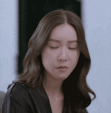 a woman with her eyes closed is wearing a black top