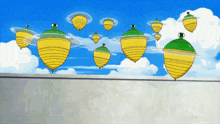 a group of yellow and green spinning tops are flying in the sky
