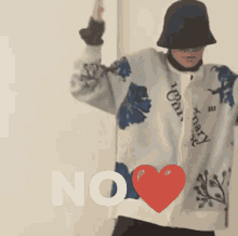 a person wearing a hat and a sweater with a heart and the word no on it
