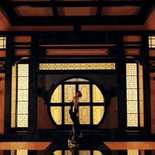 a person is standing in a room with a round window