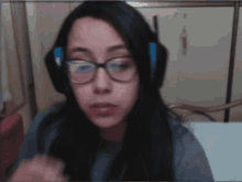 a woman wearing glasses and headphones is making a funny face