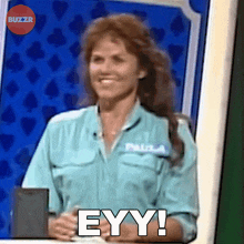 a woman in a blue shirt says eyy on a game show