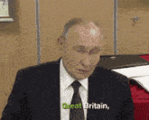 a man in a suit and tie says great britain in green letters