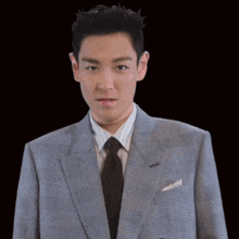 a man in a suit and tie points his finger