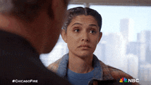 a man and a woman are looking at each other with a nbc logo behind them