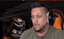 a man with a beard is wearing headphones while sitting in a chair .