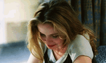 a woman with long blonde hair wearing a white sweater