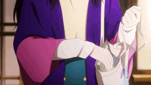 a woman in a purple and pink kimono is holding a purse