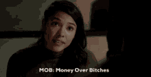 a woman says mob money over bitches in front of a dark background