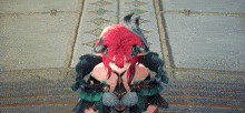 a video game character with red hair and horns is sitting on a staircase