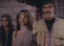 a man with a moustache is standing next to a woman
