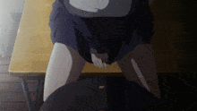 a girl in a school uniform sits on a desk