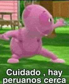 a pink cartoon character is standing on a grassy field .