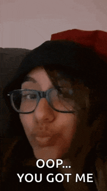 a woman wearing glasses and a black hat says oops you got me