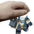 a hand is holding a toy robot on top of it .