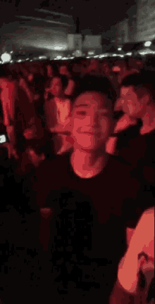 a man in a black shirt is standing in a crowd at a party .