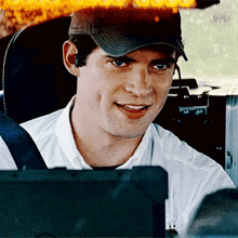 a man wearing a baseball cap and ear buds is smiling
