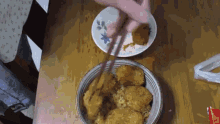 a bowl of food on a table next to a plate with a flower on it