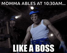 a man in a white tank top stands in front of a sign that says " momma ables at 10:30 am ... like a boss "