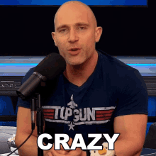 a bald man wearing a top gun shirt says crazy