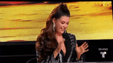 a woman with long hair is sitting in front of a television .
