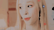 a woman with blonde hair and red lipstick is standing in front of a painting