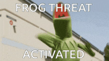 kermit the frog is standing in front of a building with the words " frog threat activated " above him