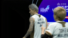 a man with a tattoo on his arm is wearing a jersey that says chen ti malaysia
