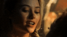 a close up of a woman 's face with her eyes closed and her mouth open in a dark room .