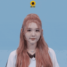 a girl with red hair is making a face with a sunflower in the background