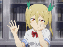 a girl with blonde hair and green leaves in her hair is waving